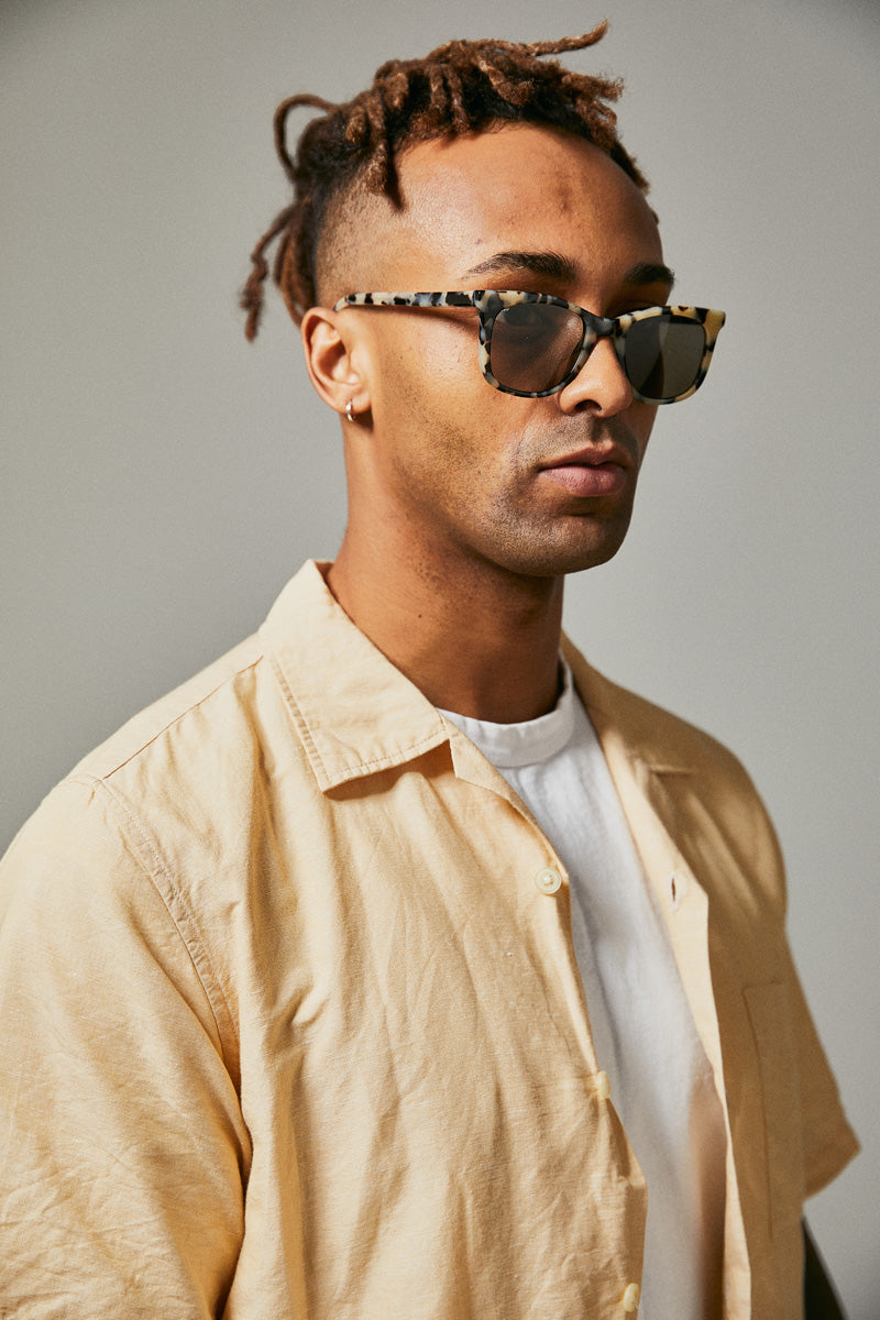 Male model wearing black and white prescription sunglasses from Ozeano Vision