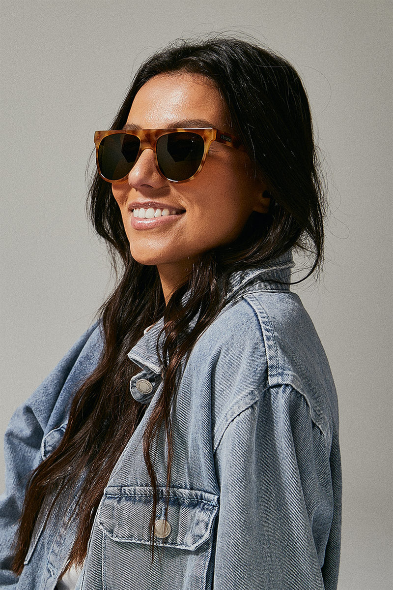 Female model wearing orange prescription sunglasses from Ozeano Vision
