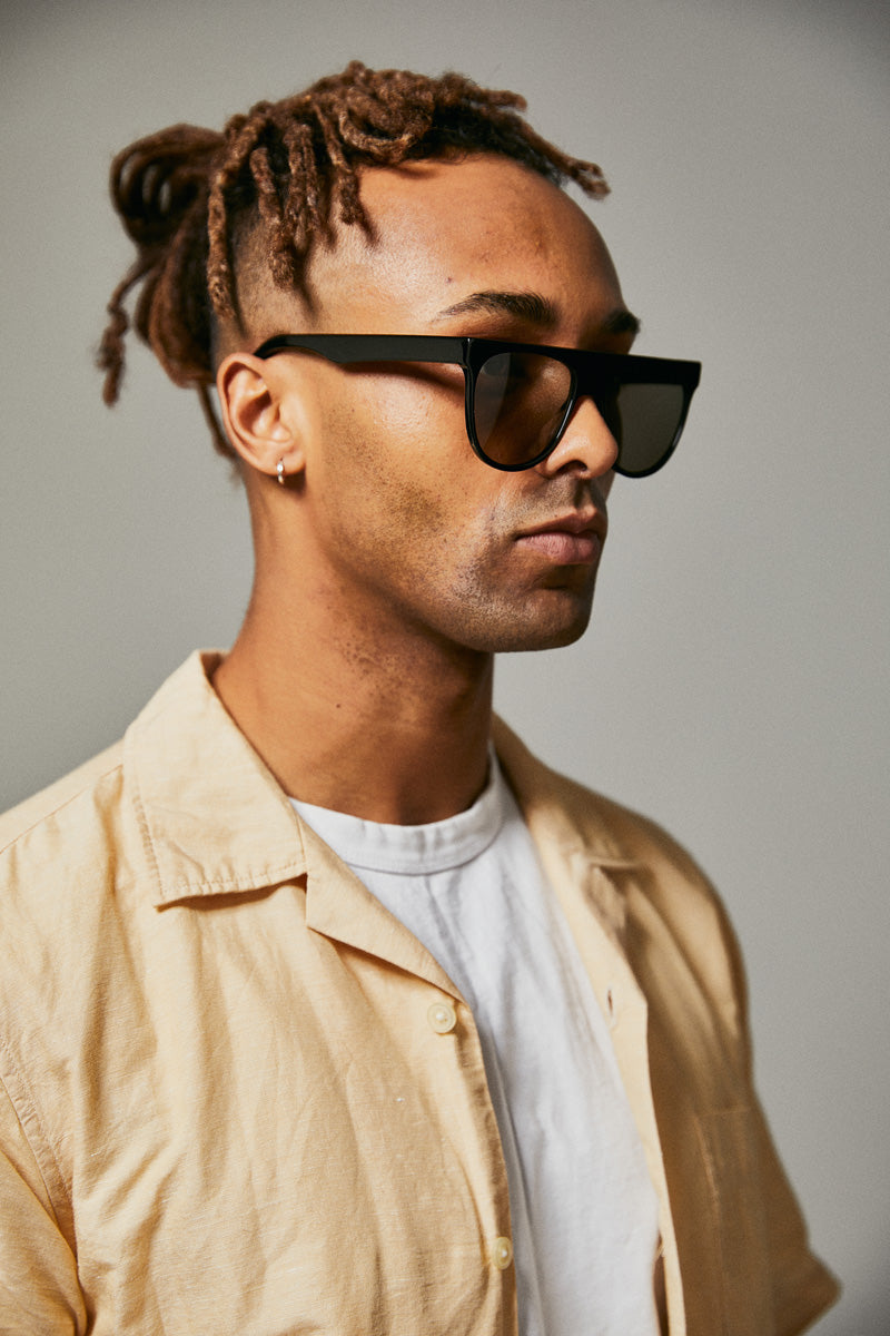 Male model wearing black prescription sunglasses from Ozeano Vision