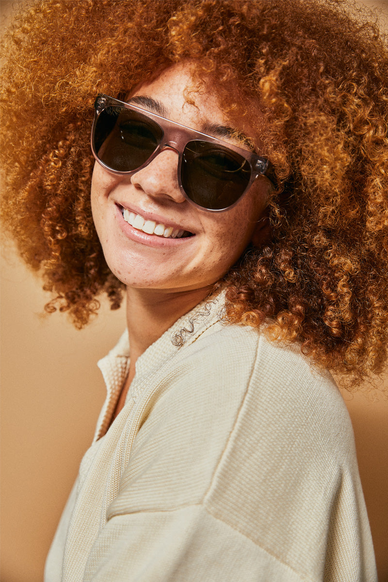 Female model wearing grey prescription sunglasses from Ozeano Vision