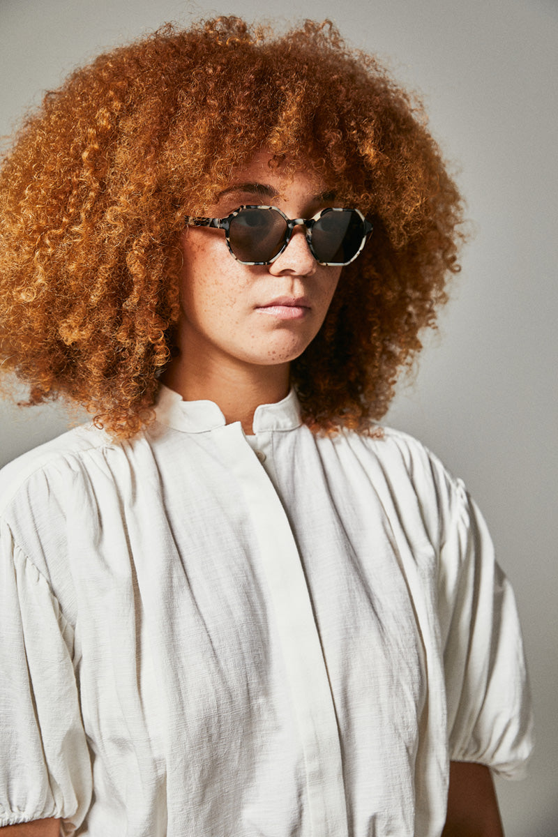 Female model wearing black and white polarised sunglasses from Ozeano Vision
