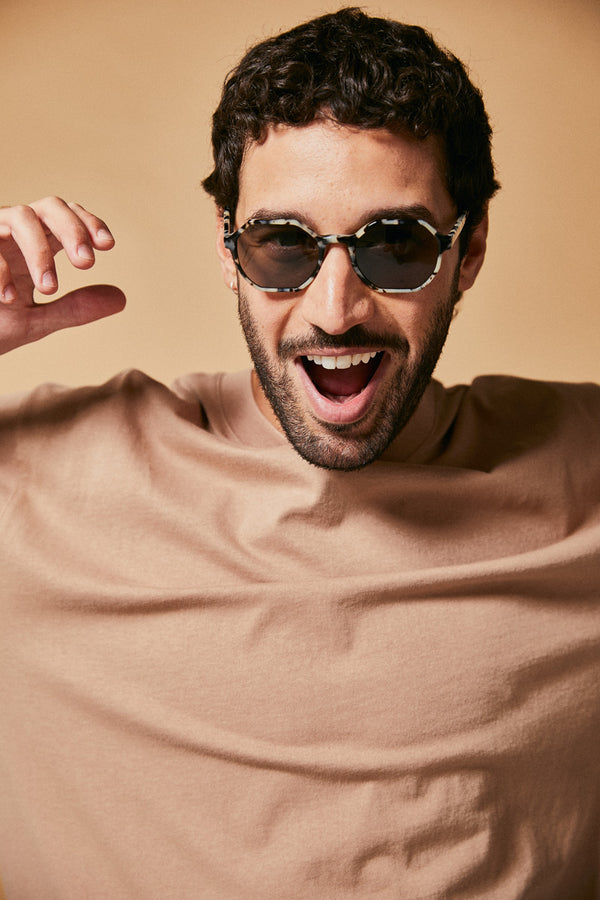 Male model wearing black and white polarised sunglasses from Ozeano Vision
