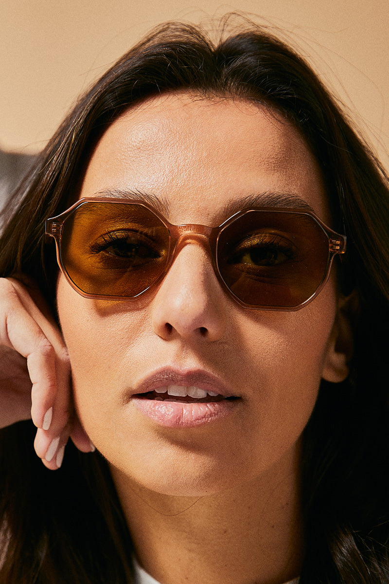 Female model wearing brown prescription sunglasses from Ozeano Vision