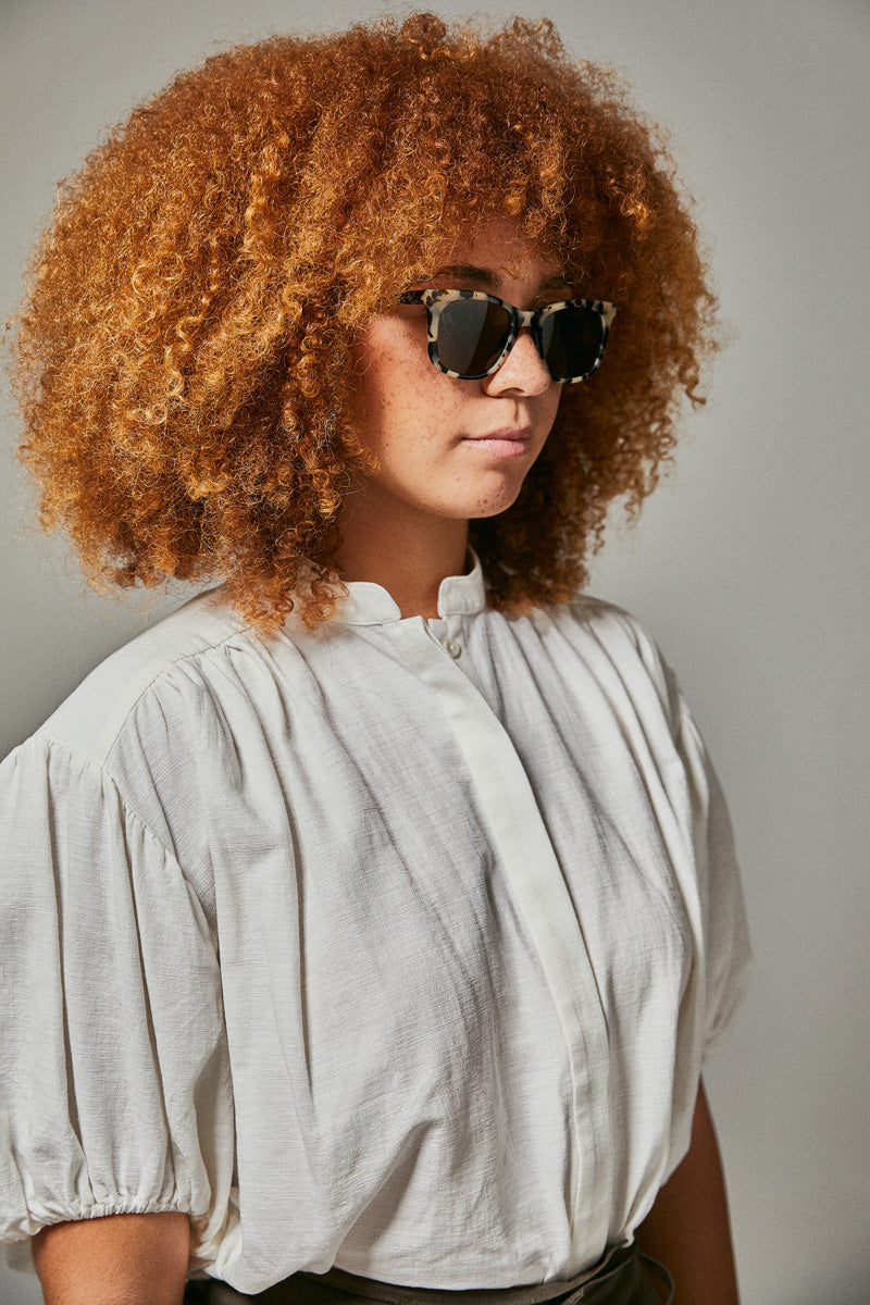 Female model wearing black and white prescription sunglasses from Ozeano Vision