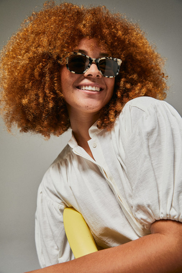 Female model wearing black and white polarised sunglasses from Ozeano Vision