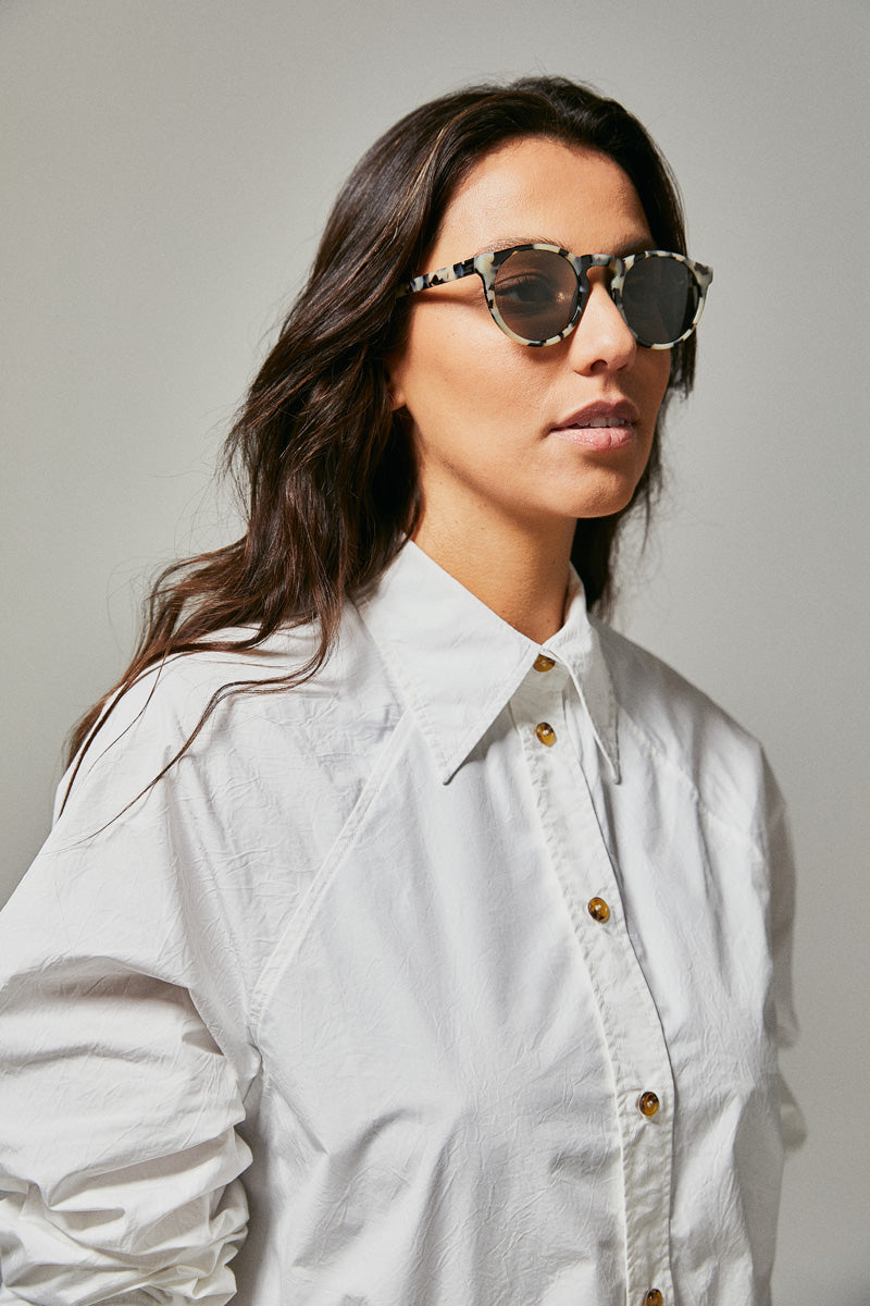 Female model wearing black and white polarised sunglasses