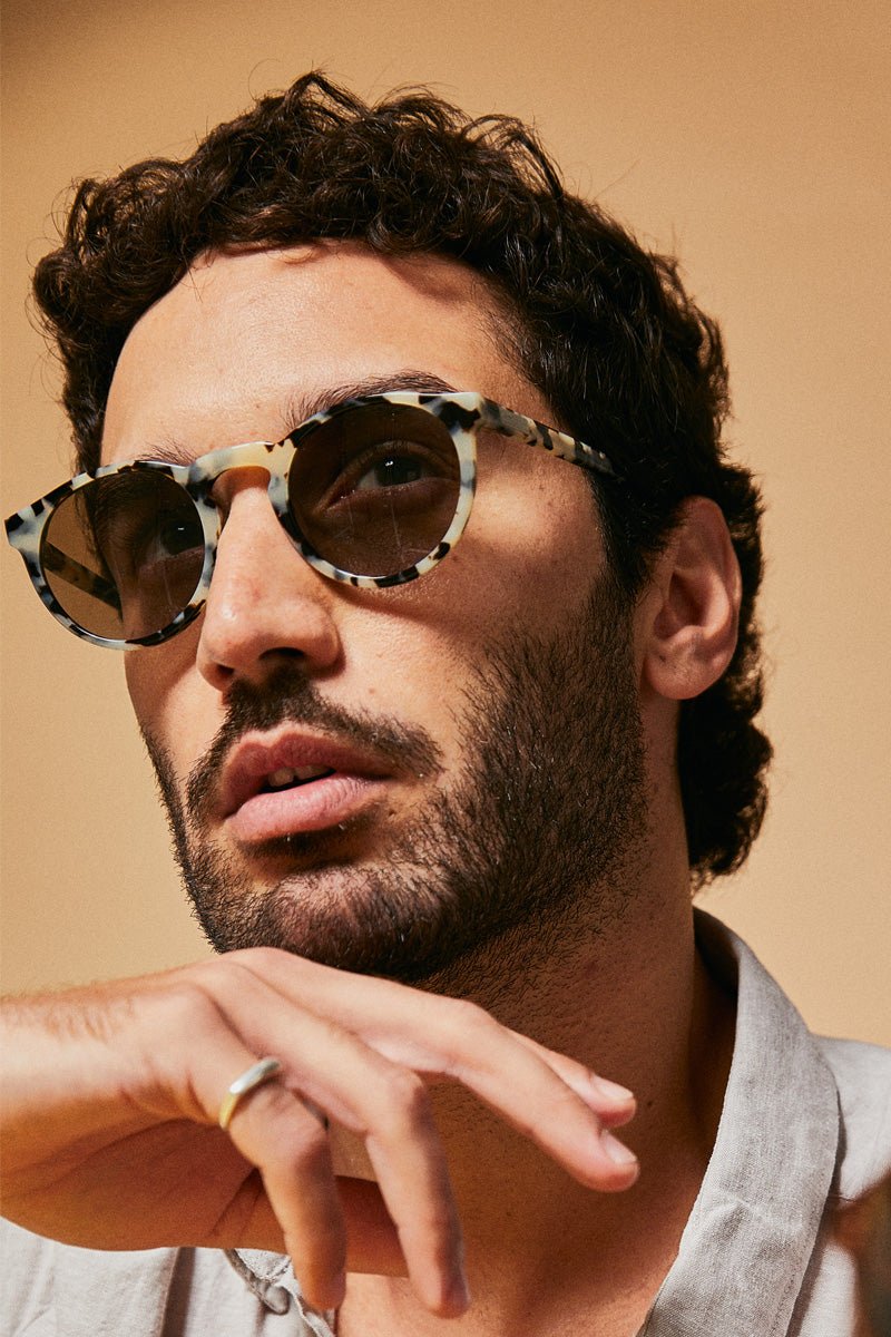 Male model wearing black and white polarised sunglasses