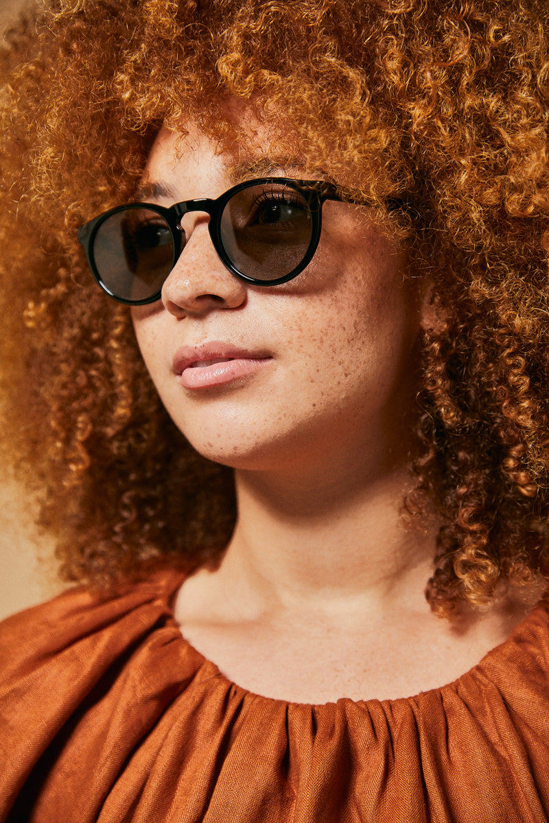 Female model wearing black polarised sunglasses